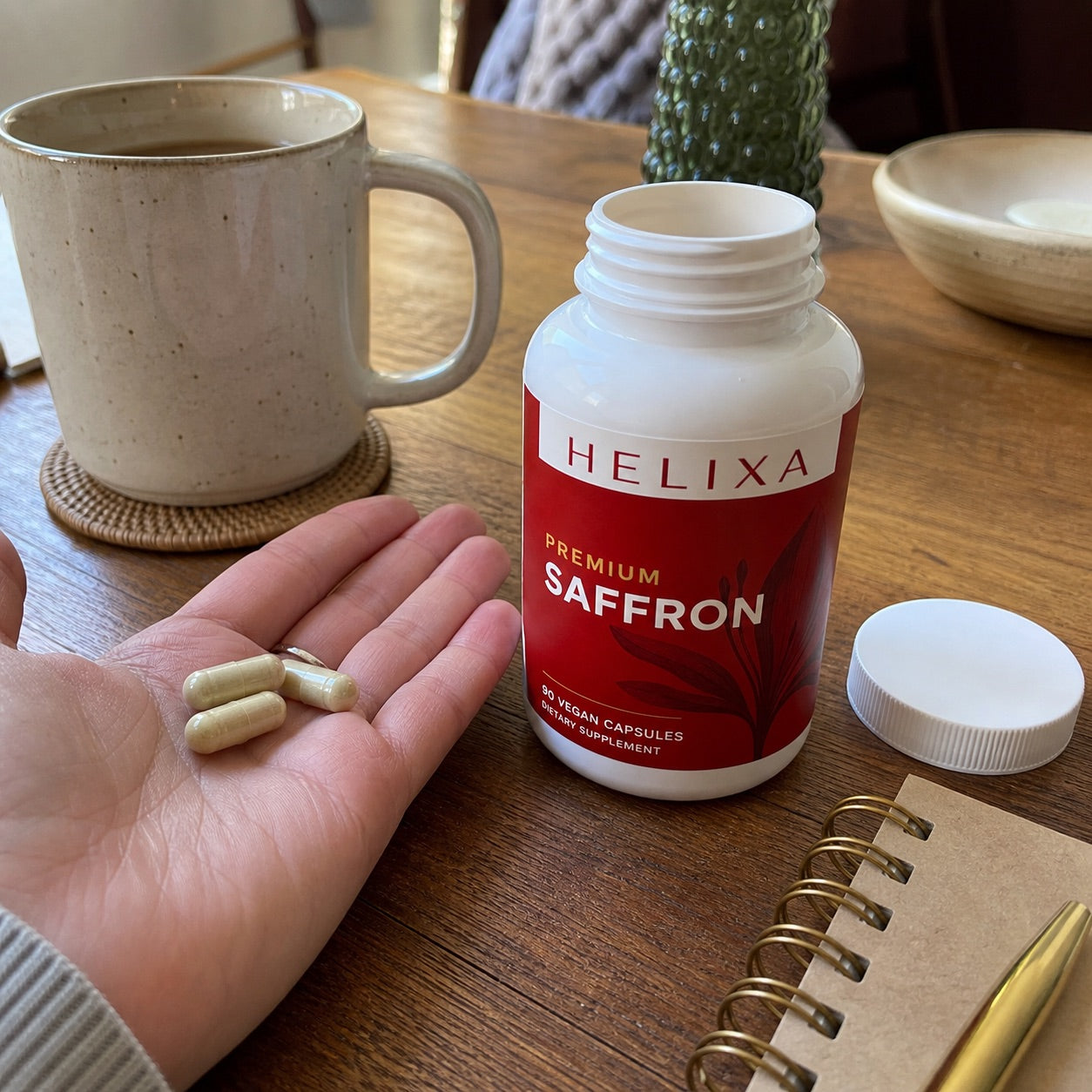 Open Helixa Premium Saffron bottle with capsules on a table
